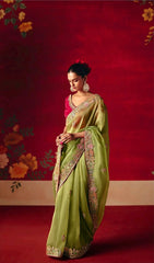 Woman in a green saree with floral background