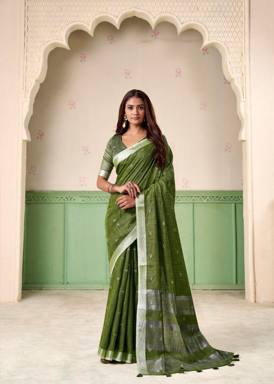 Woman wearing a green saree with a white border in front of an archway.
