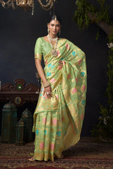 Woman in a green saree with a pattern against a dark background