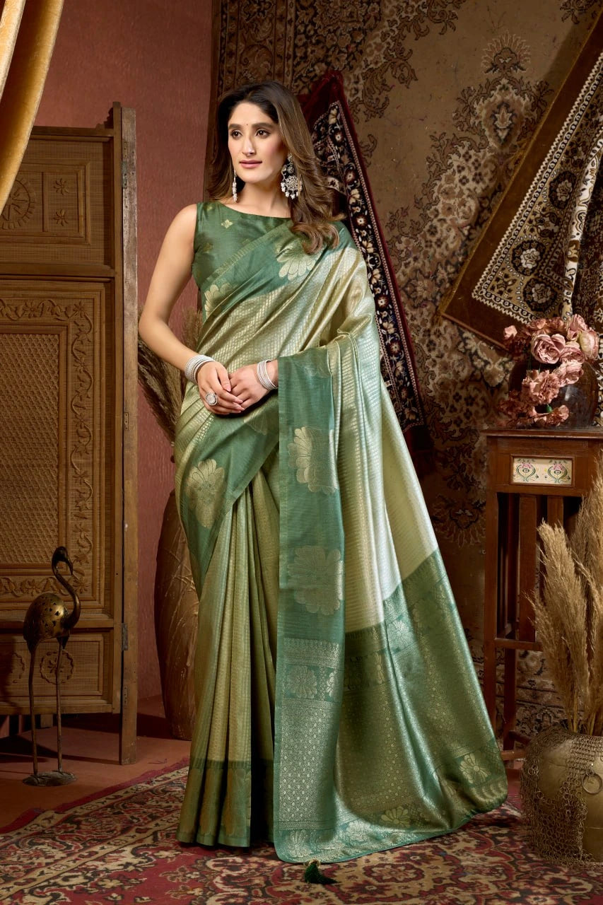Woman in a green saree standing in an ornate room with decorative elements.