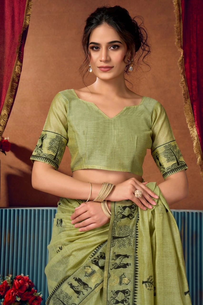 Woman wearing a green saree with a traditional backdrop