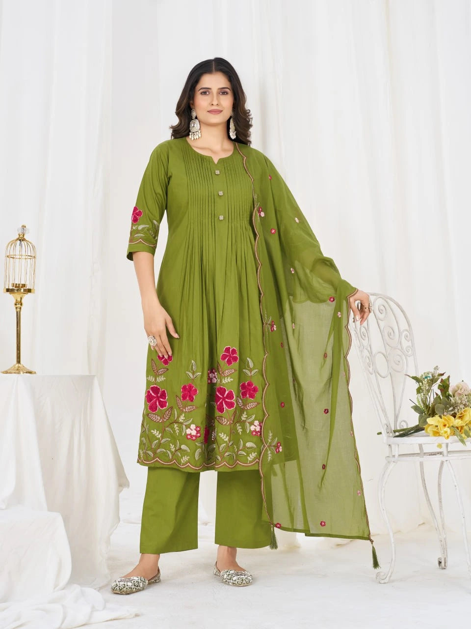 Woman wearing a green embroidered outfit with a white background