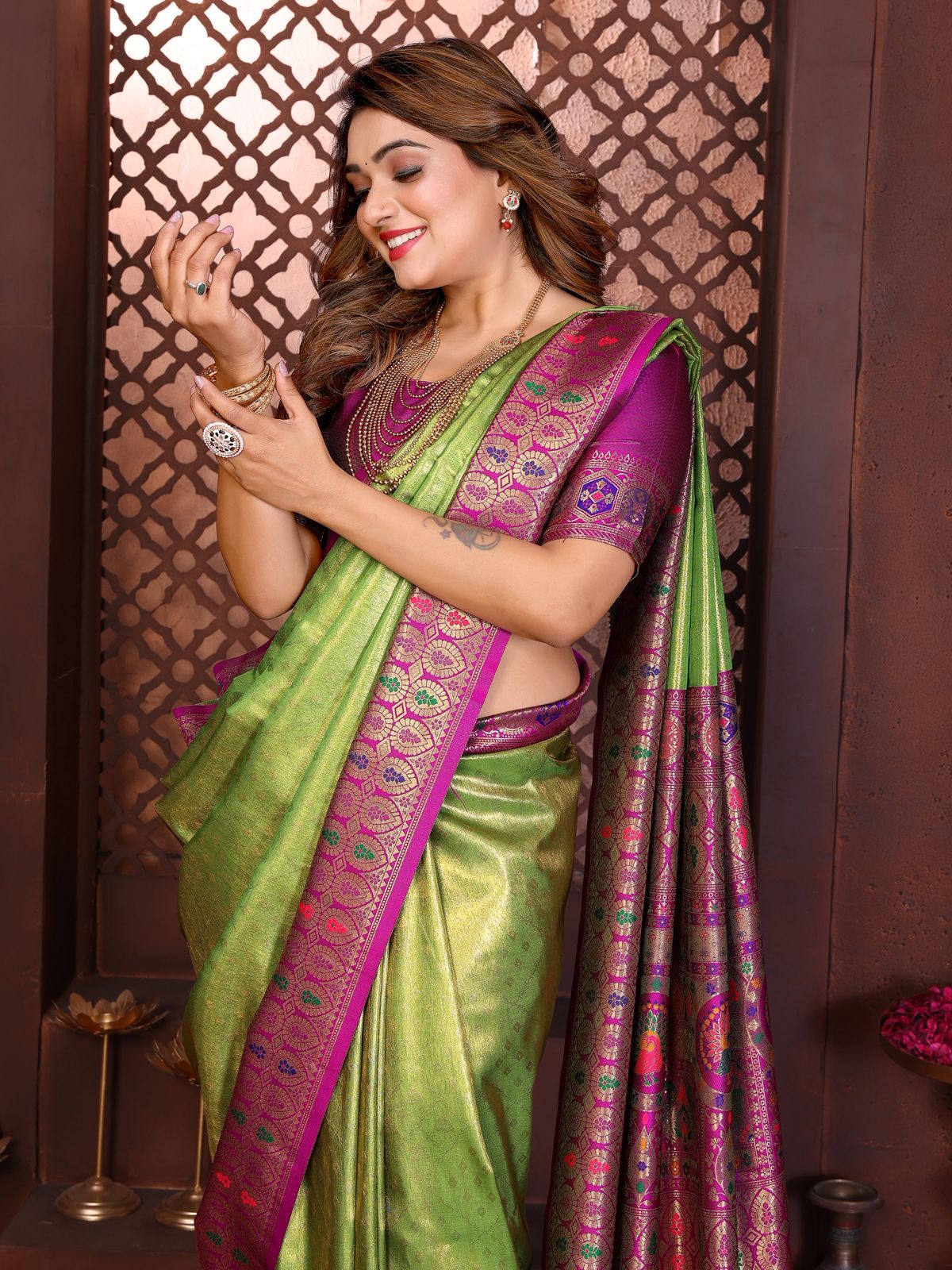 Woman wearing a green and purple saree with a decorative background