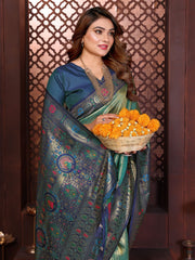 Woman in traditional saree holding a basket of marigold flowers against a decorative wall.