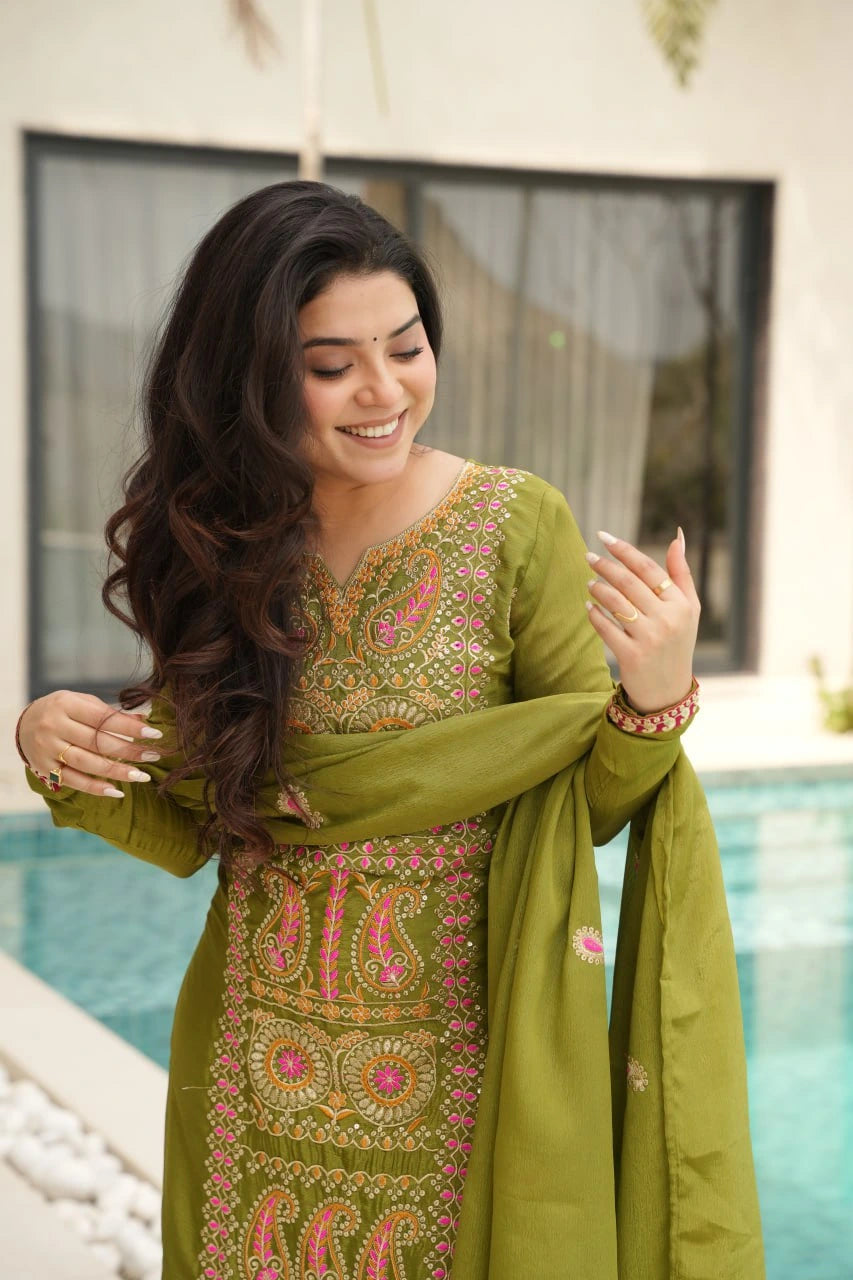 Woman in a green embroidered traditional outfit by a pool