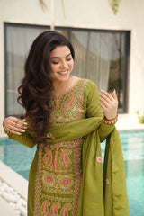 Woman in a green embroidered traditional outfit by a pool