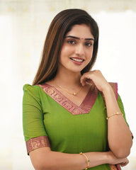Woman wearing a green traditional outfit with gold jewelry on a white background