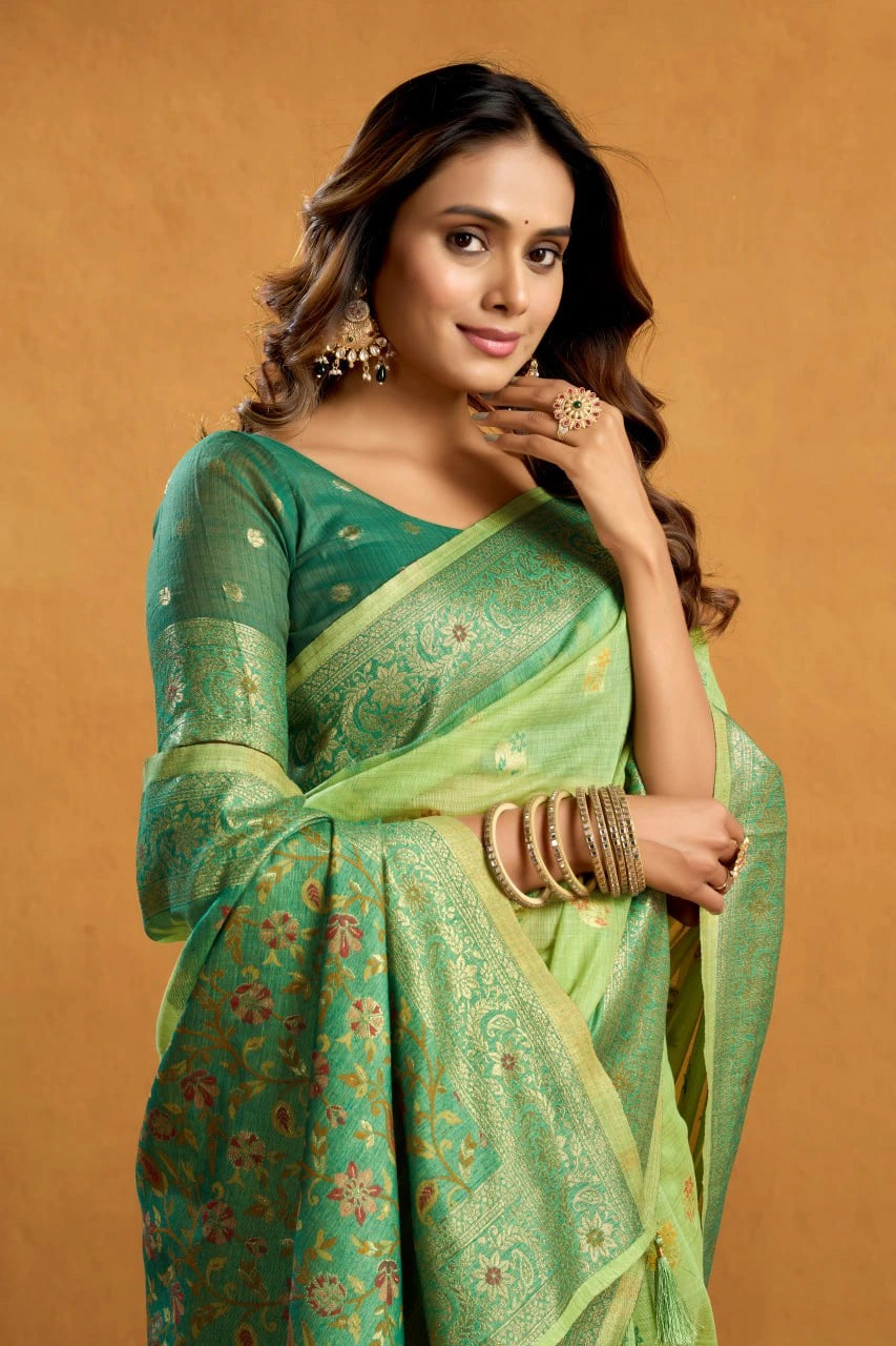 Woman wearing a green saree with a gold border on a beige background