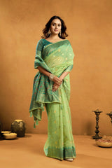 Woman wearing a green saree with a brown background