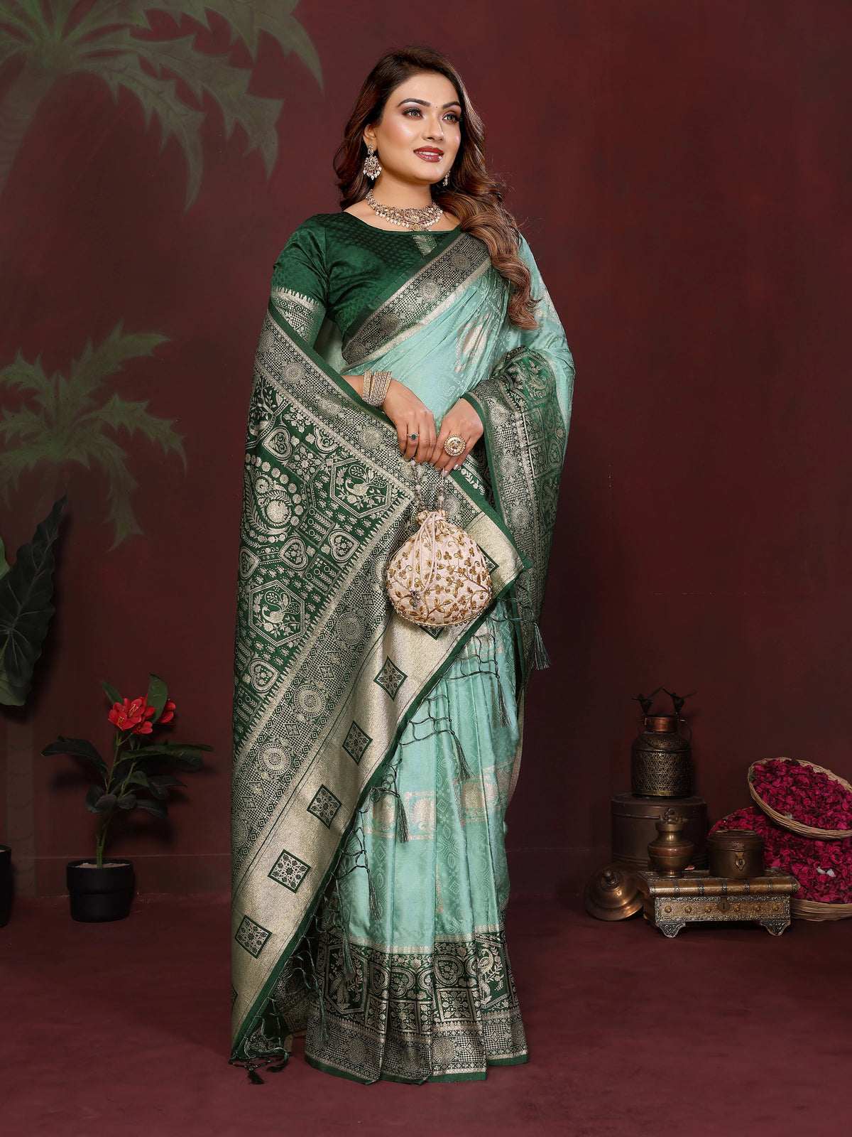 Woman wearing a green and white saree with a patterned border against a dark background.