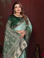 Woman wearing a green saree with a patterned border against a dark background