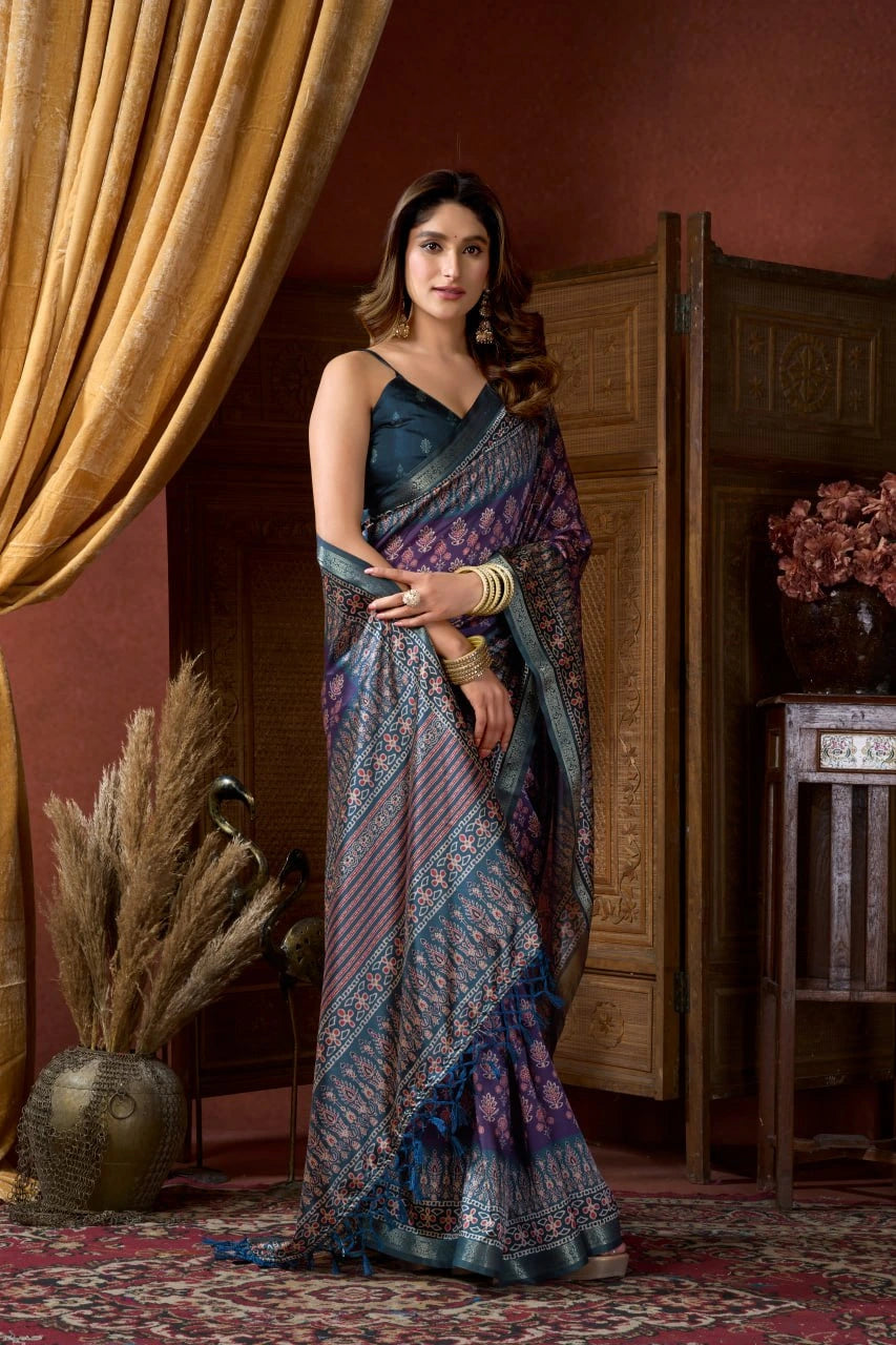 Woman in a traditional saree standing in a room with decorative elements.