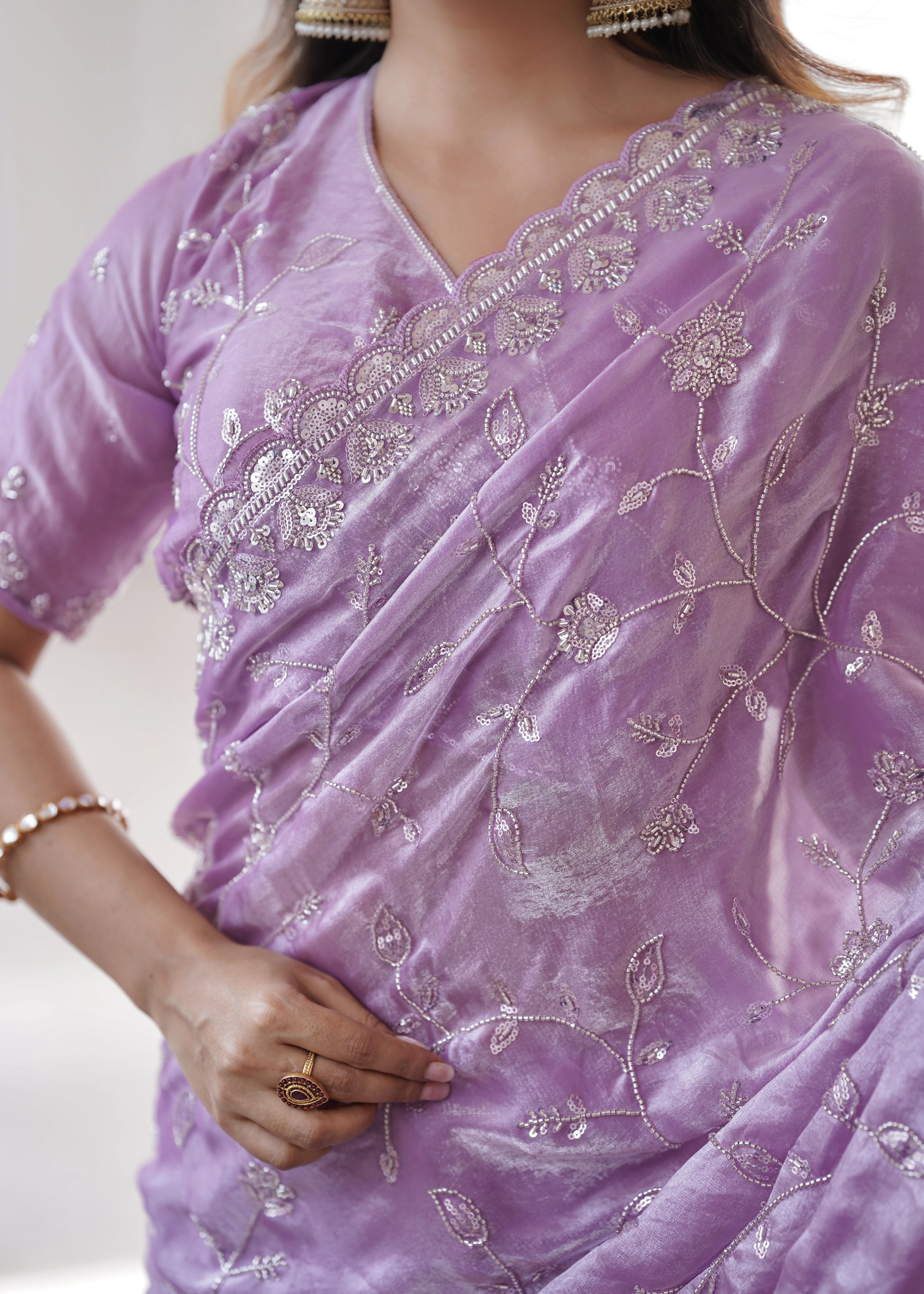 Purple saree with intricate silver embroidery on a neutral background