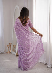 Woman wearing a purple saree with a white background