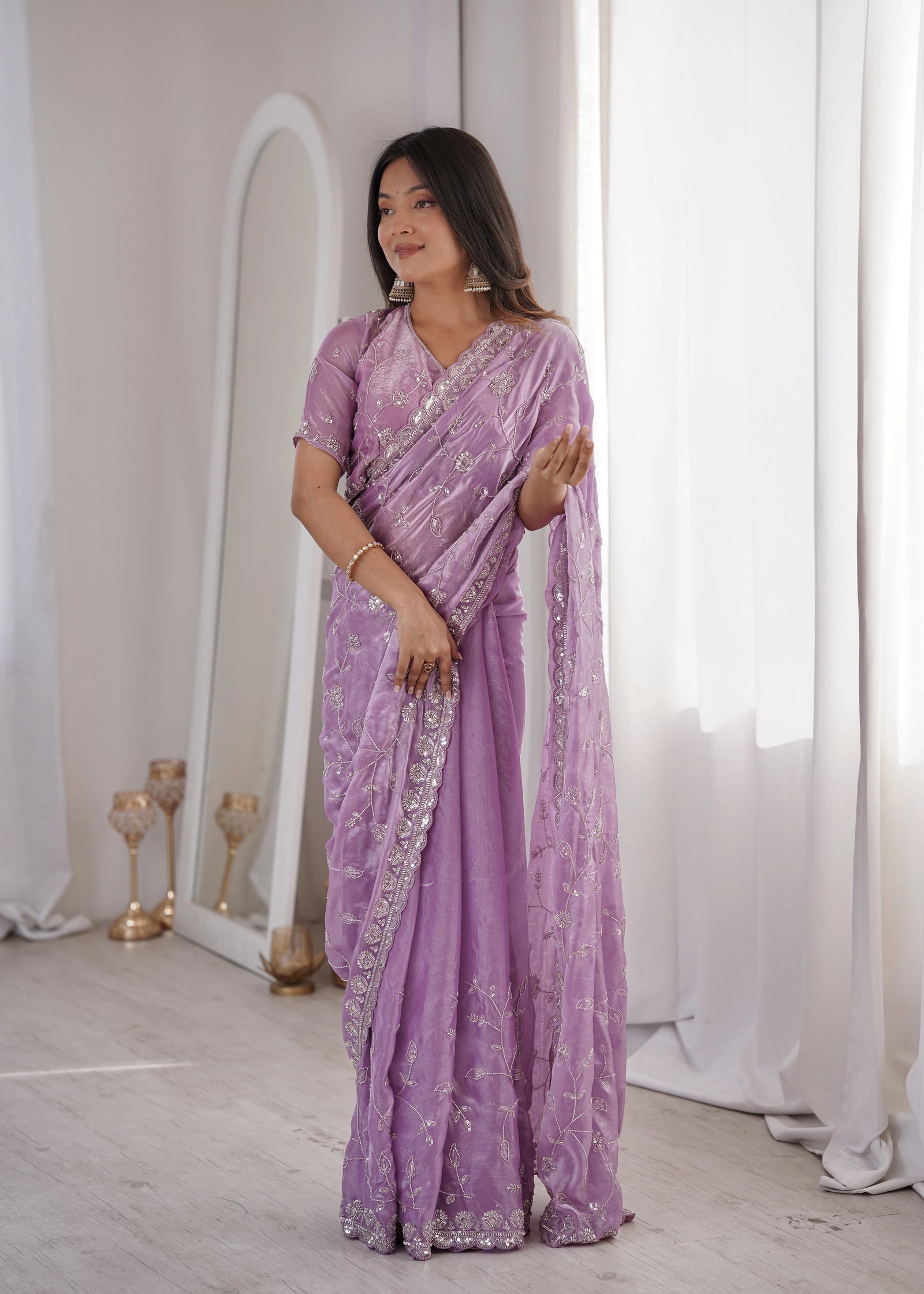 Woman wearing a purple saree with silver border indoors