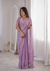 Woman wearing a purple saree with silver border indoors