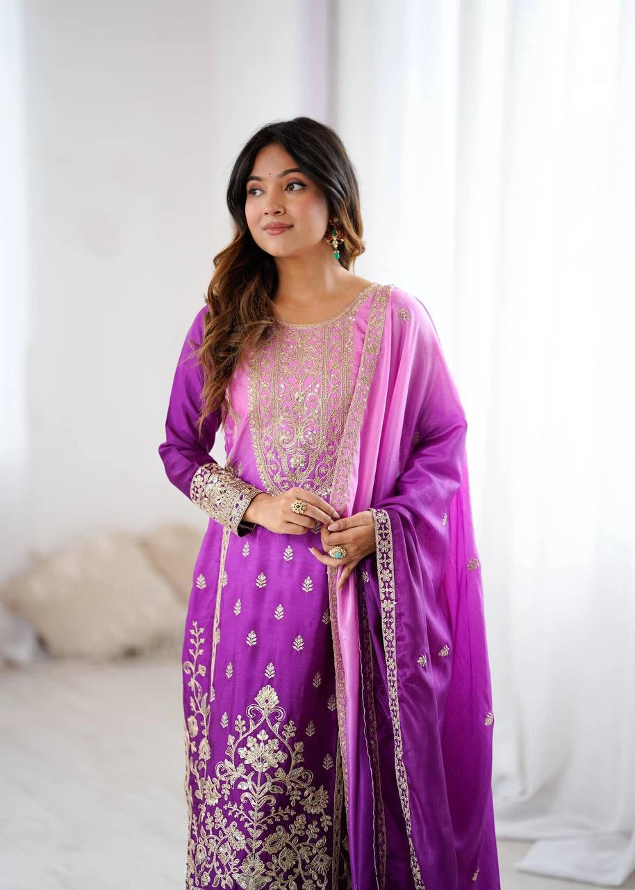 Woman wearing a purple and pink traditional outfit with white embroidery.