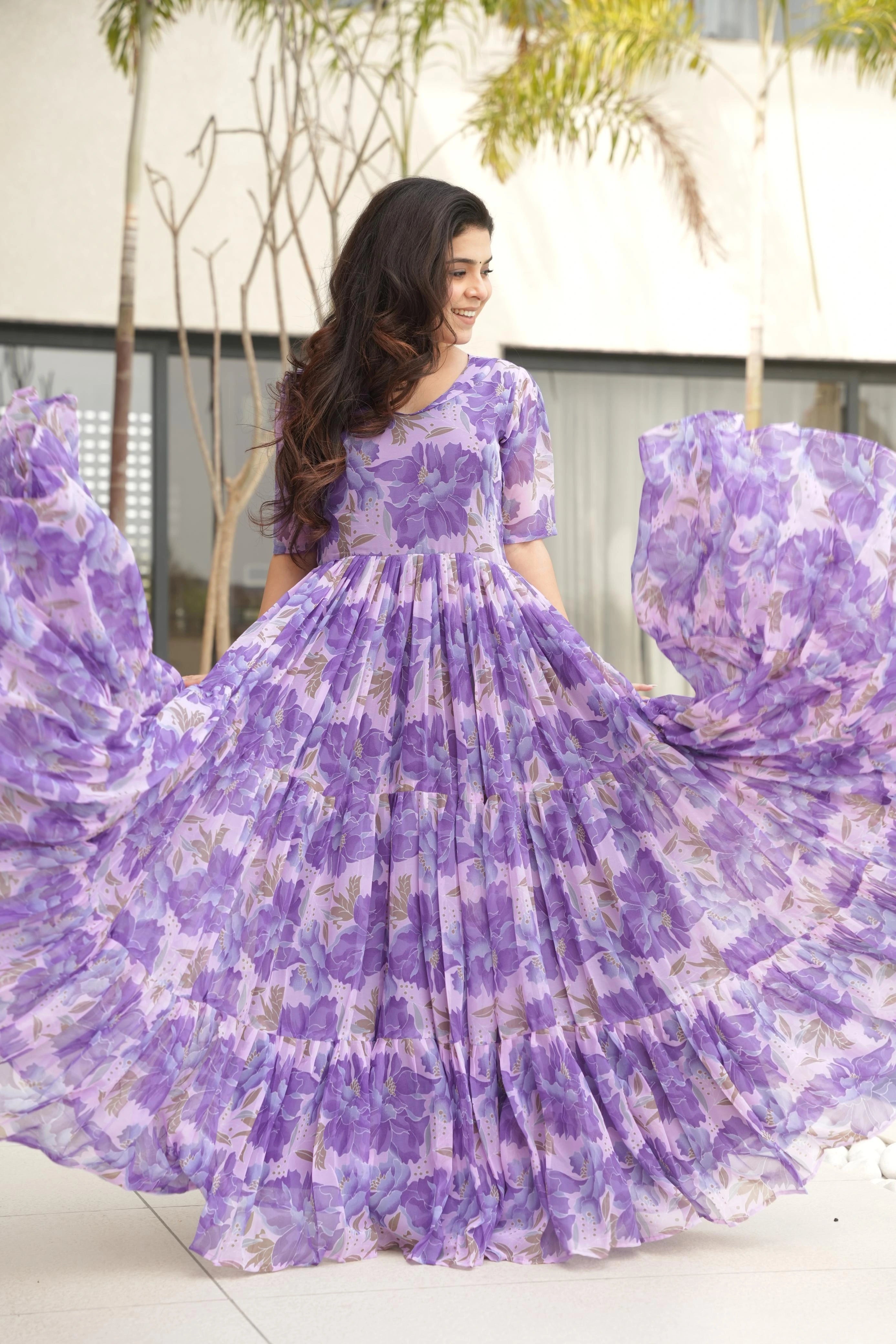 Woman wearing a purple floral dress in an outdoor setting