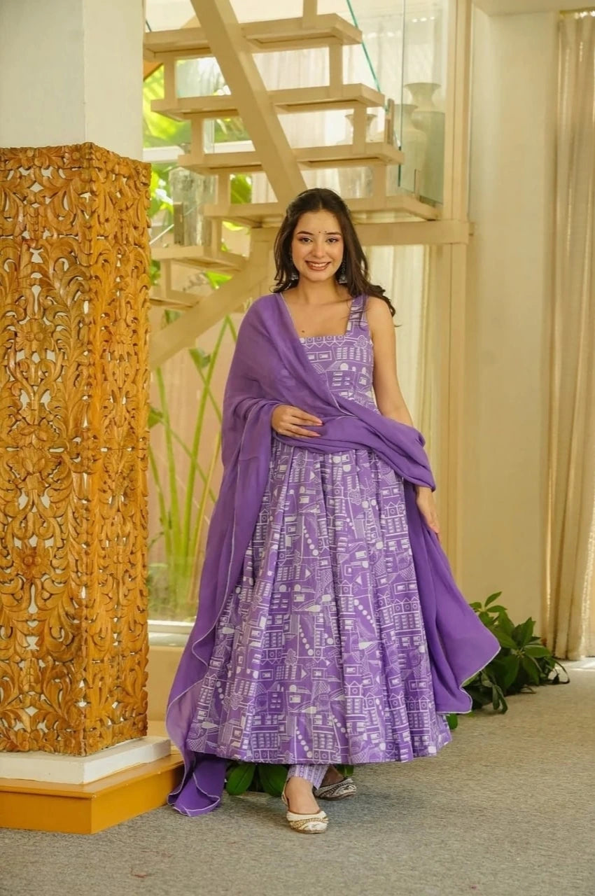Woman in a purple traditional outfit standing in a room with decorative elements.