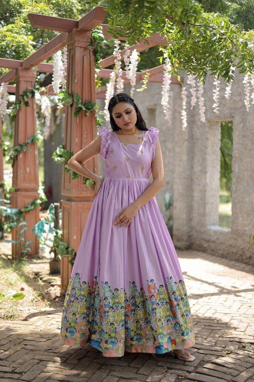 Woman in a purple dress with floral hem standing outdoors under a wooden archway.