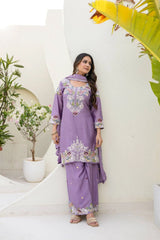 Woman wearing a purple embroidered outfit with plants in the background