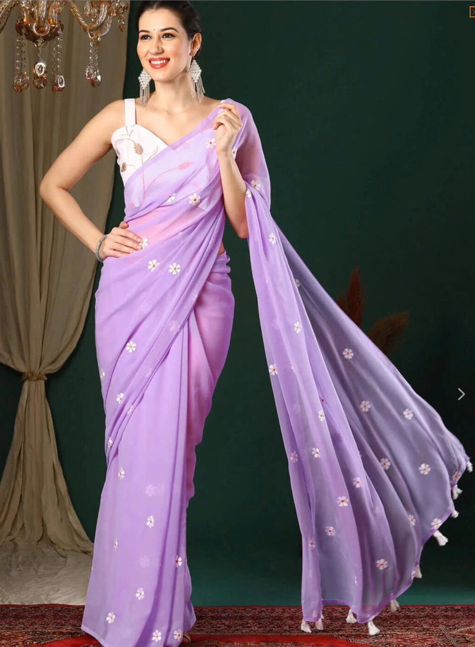 Woman wearing a lavender saree with a white blouse against a dark background