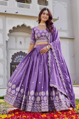Woman in a purple traditional outfit standing in front of a white architectural background