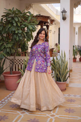 Woman in a purple top and beige skirt standing in an elegant indoor setting with plants.