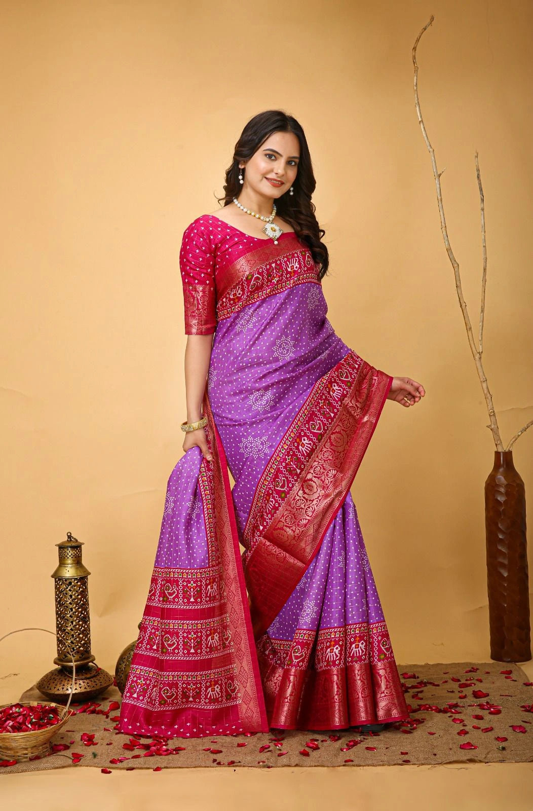 Woman wearing a traditional purple and red saree on a beige background