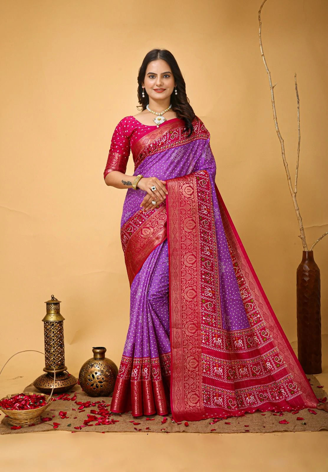 Woman wearing a purple and red saree with a beige background