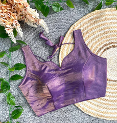 Purple bikini top on a textured surface with flowers and leaves