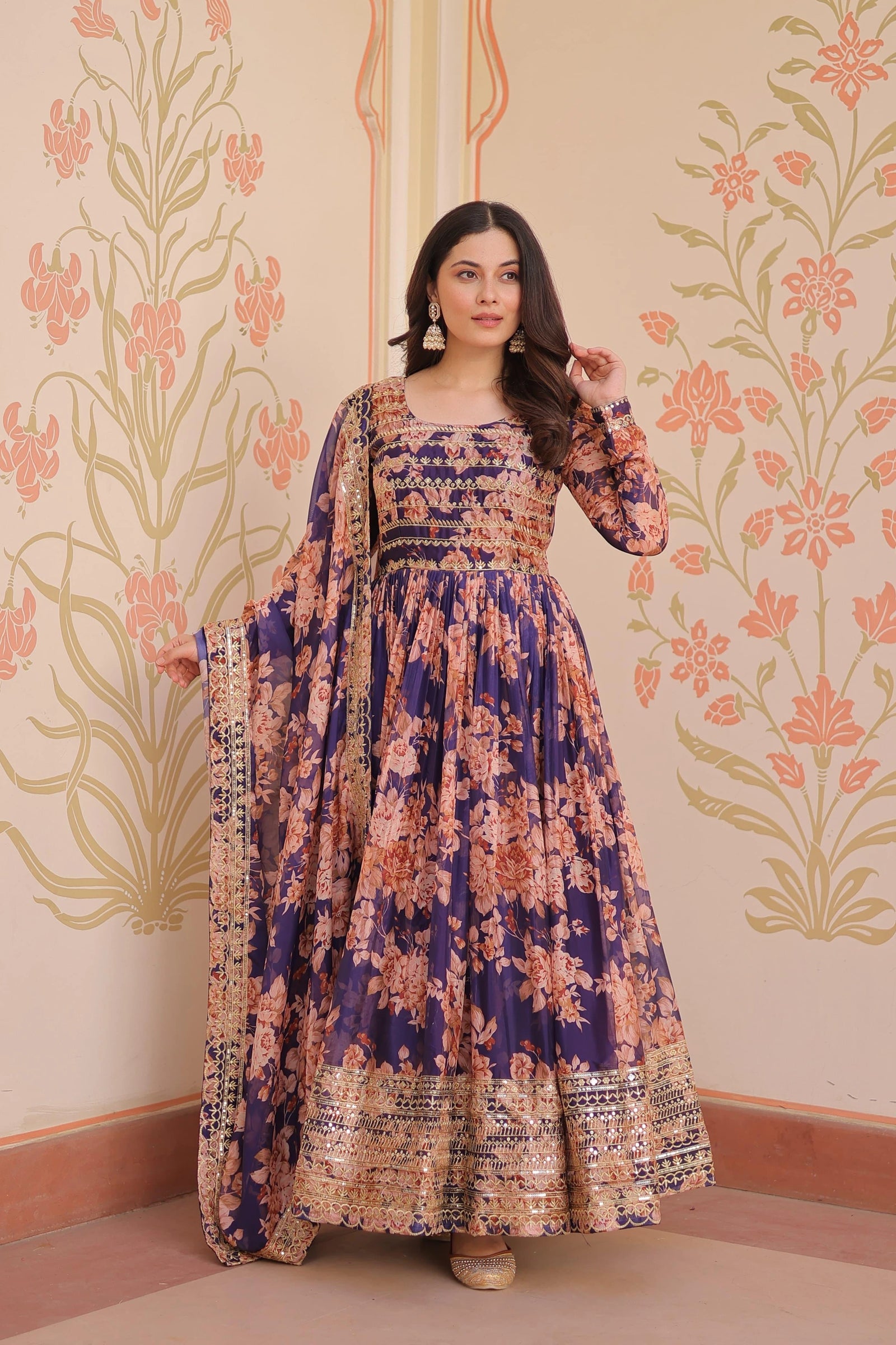 Woman wearing a floral dress with a patterned wall in the background