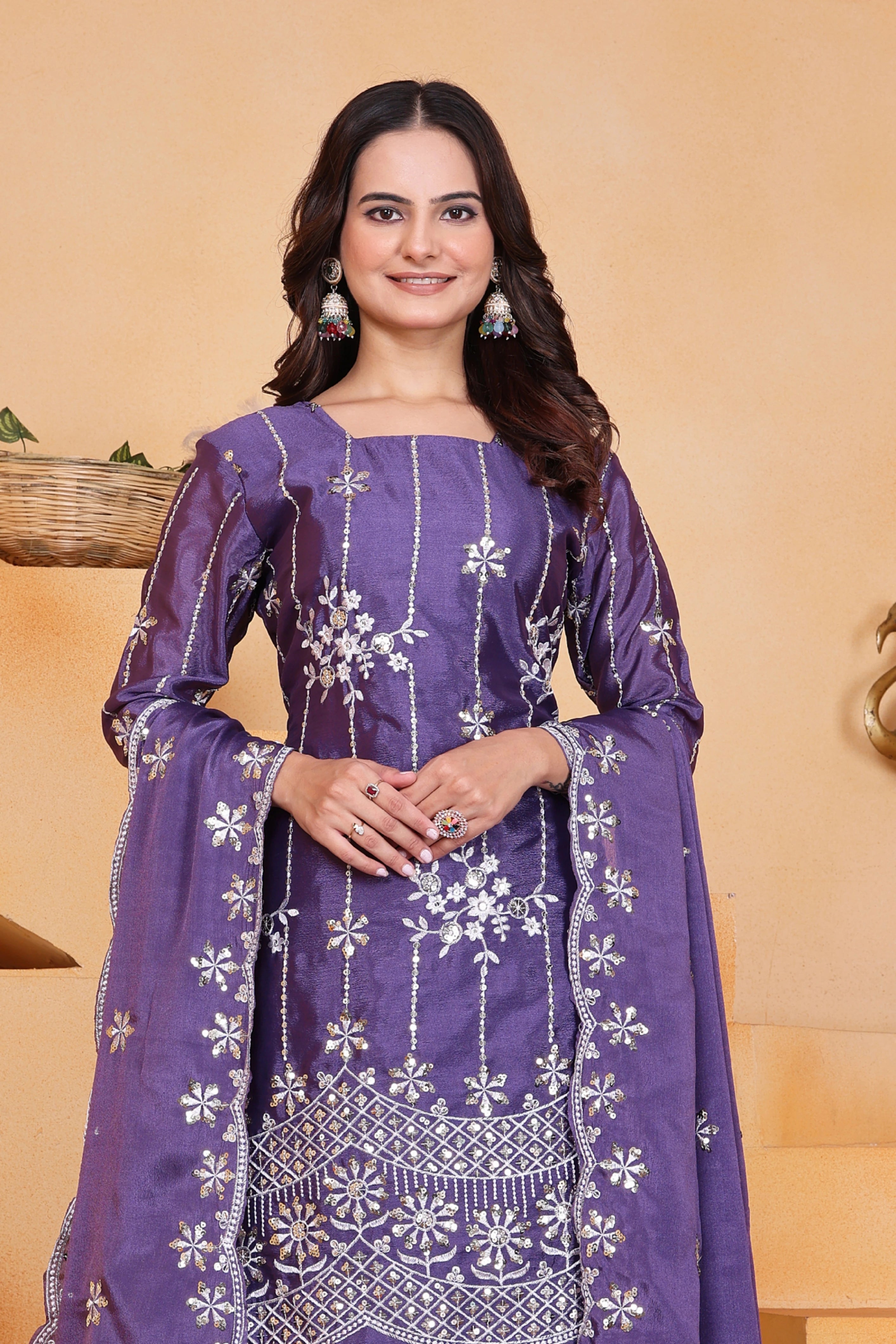 Woman wearing a purple traditional outfit with white patterns on a beige background