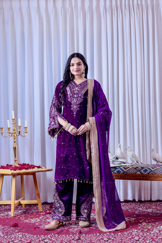 Woman in a purple traditional outfit with a white curtain background