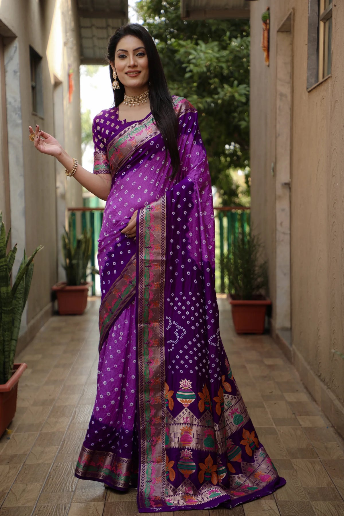 Woman wearing a purple saree with a colorful pattern in an outdoor setting