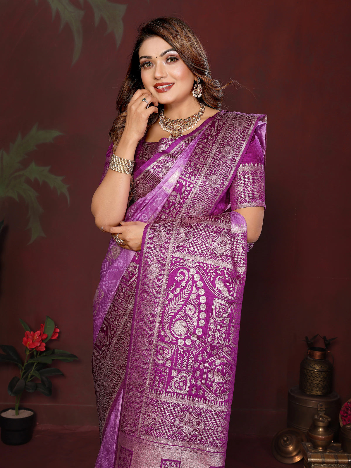 Woman wearing a purple saree with intricate patterns against a dark background
