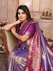 Woman in a purple saree sitting on a chair with decorative background