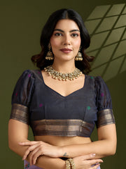 Woman wearing a traditional outfit with jewelry against a green background