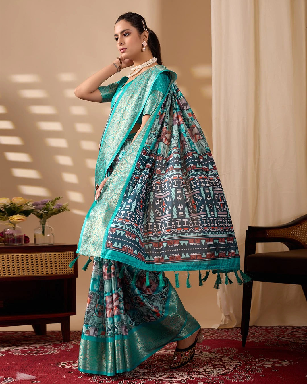 Woman wearing a traditional saree with a patterned design in a room setting.