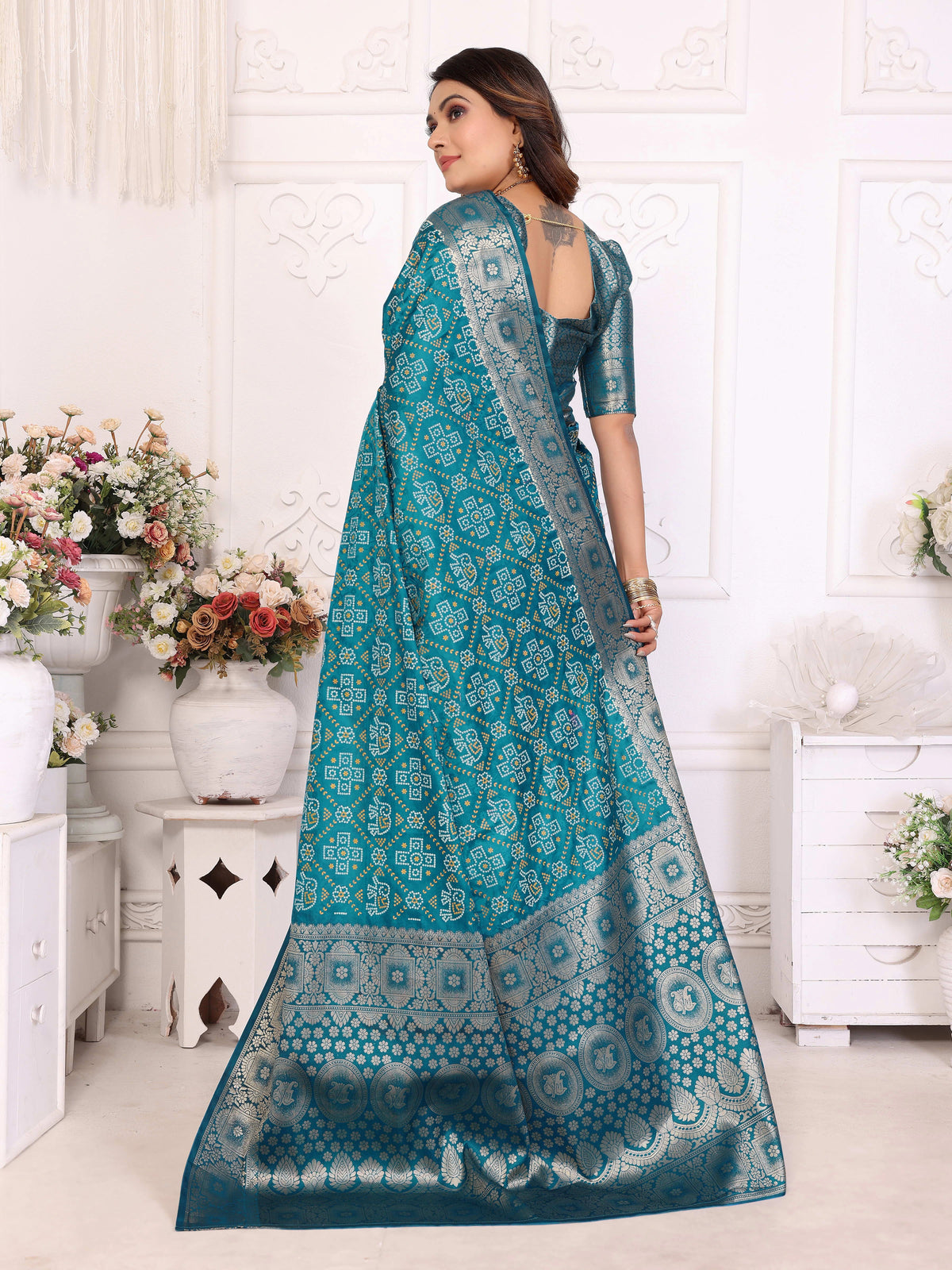 Woman wearing a teal saree with a white background