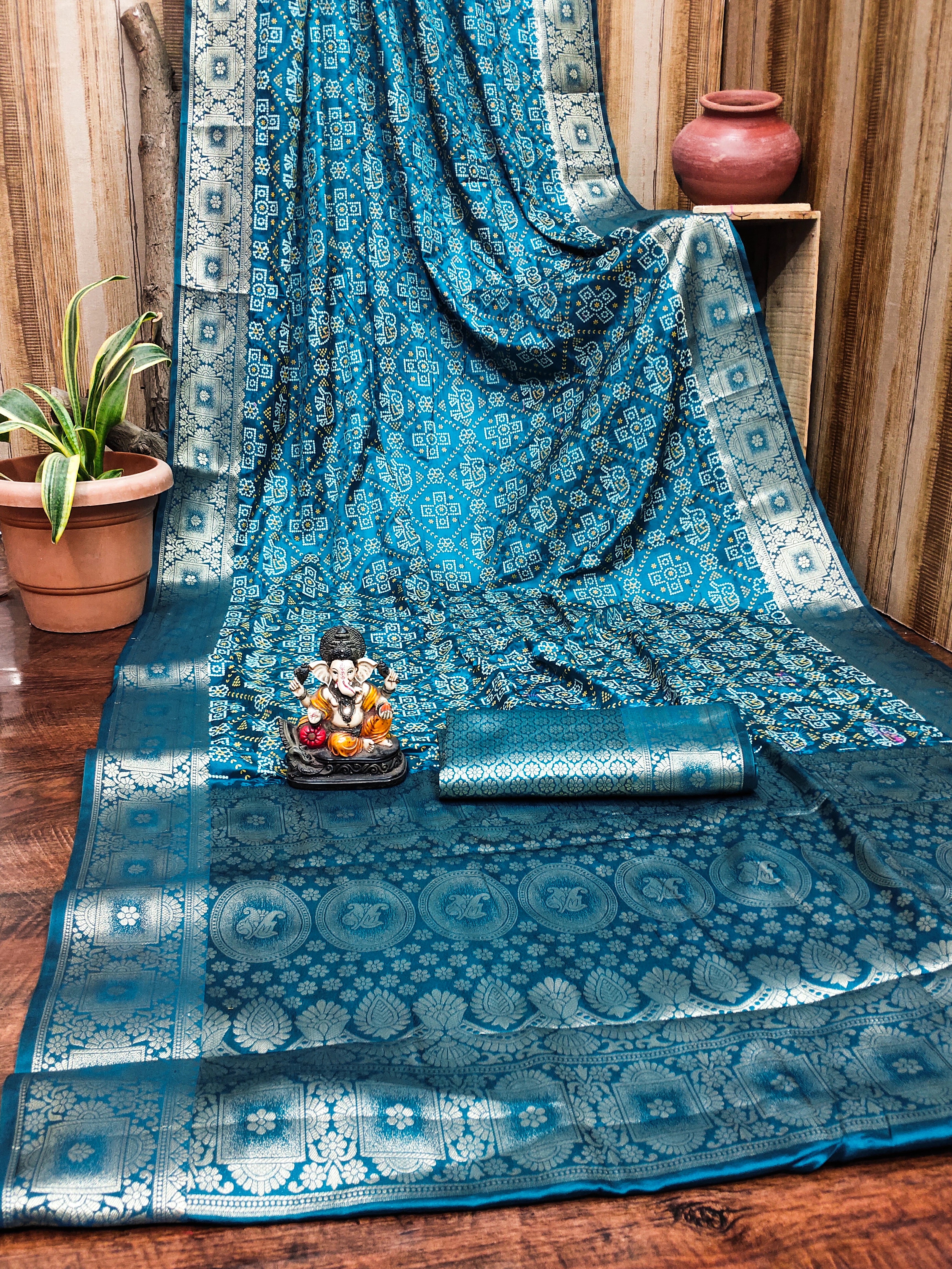 Blue patterned fabric draped over a surface with decorative items on a wooden floor.