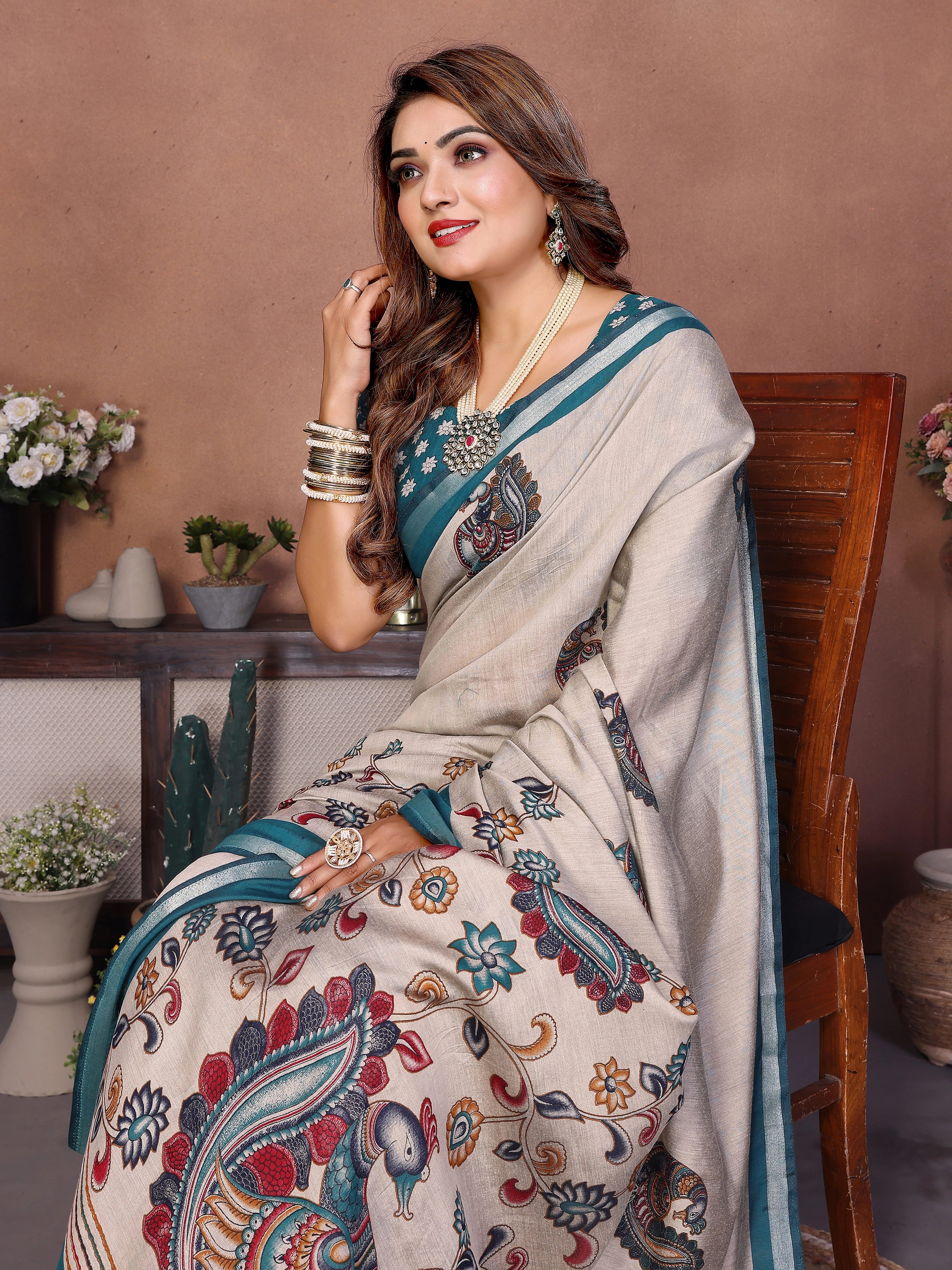 Woman wearing a traditional saree with a floral pattern in an indoor setting
