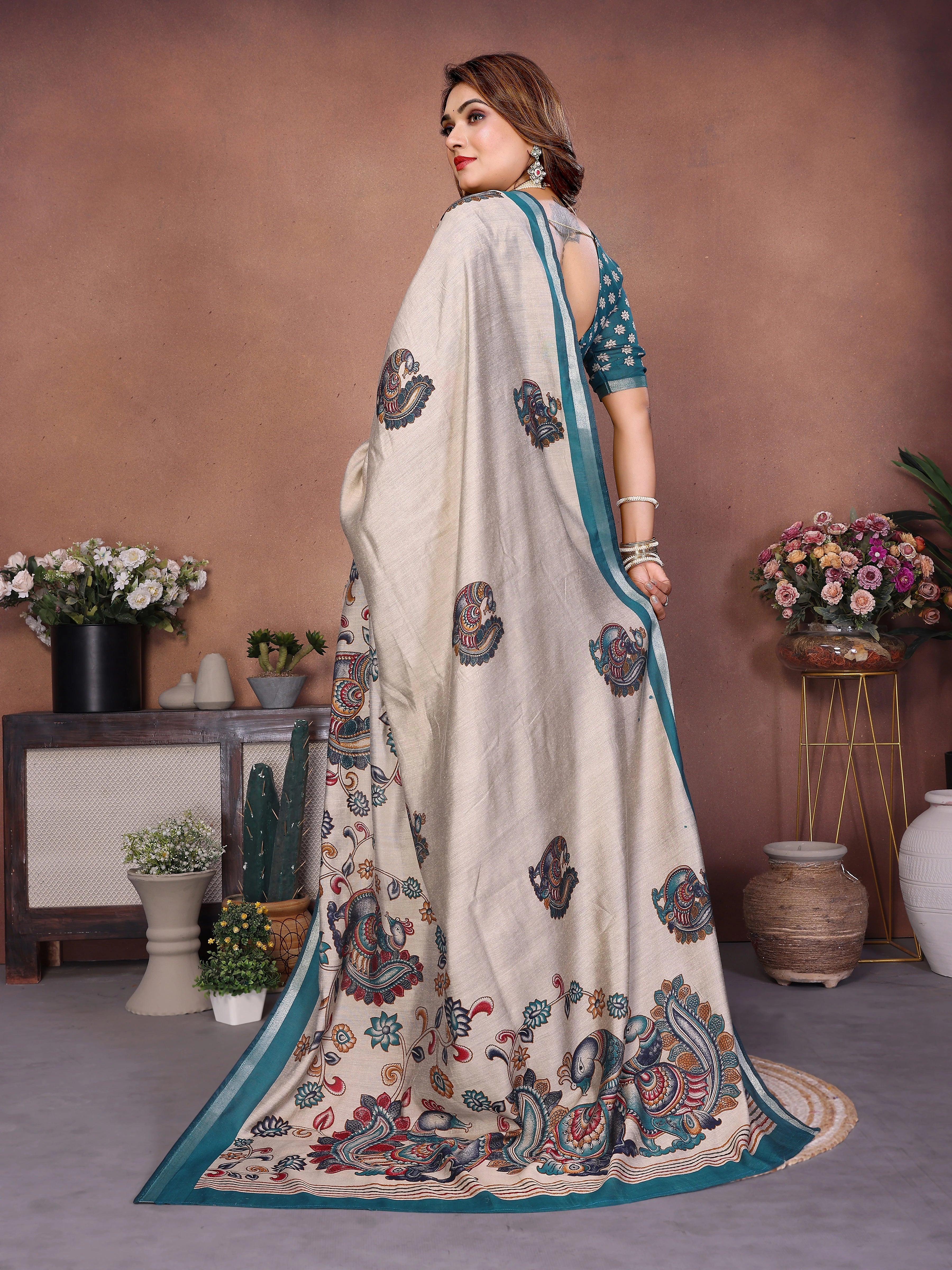 Woman wearing a traditional saree with intricate patterns in a decorated indoor setting