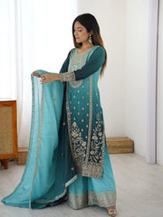 Woman holding a blue embroidered traditional outfit with a white background