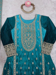 Teal embroidered dress with silver detailing on a light gray background