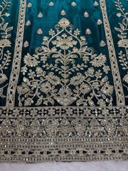 Decorative fabric with intricate gold embroidery on a teal background