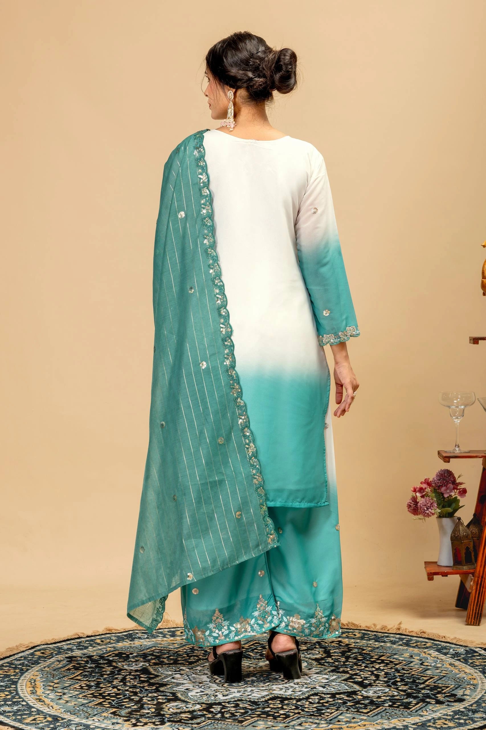 Woman wearing a white kurta with a green dupatta in a room setting.