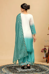 Woman wearing a white kurta with a green dupatta in a room setting.