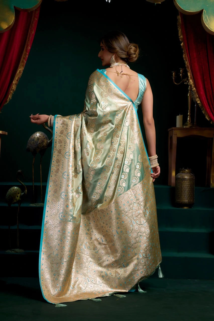 Woman in a traditional saree standing on a stage with red curtains and dark background