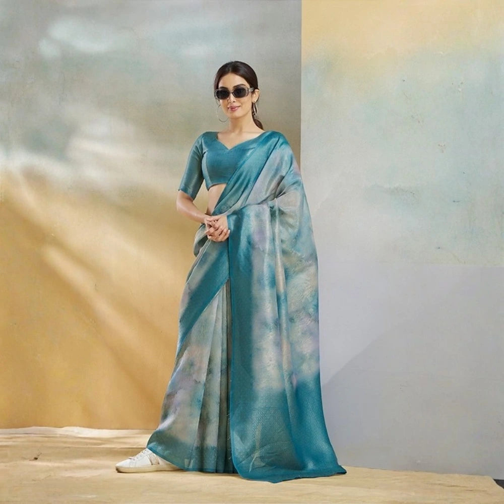 Woman wearing a blue saree with a gradient effect against a neutral background